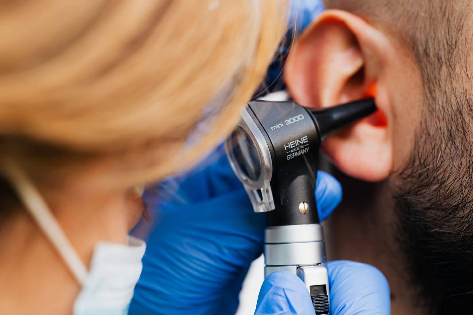 Doctor giving a man an ear exam.