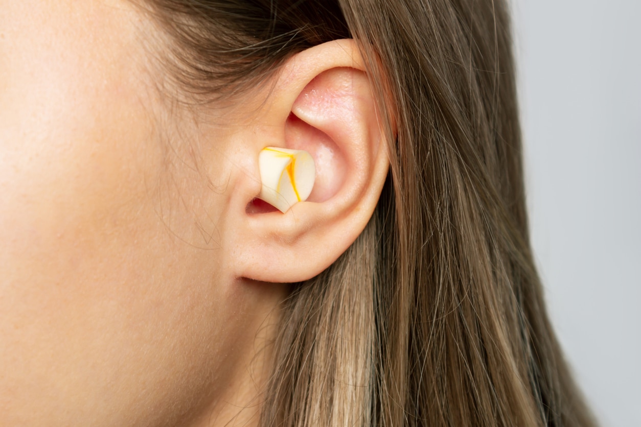 Close up of a woman wearing earplugs.