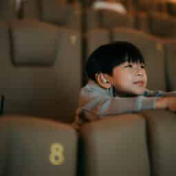 Young boy with hearing aids smiling in a theater