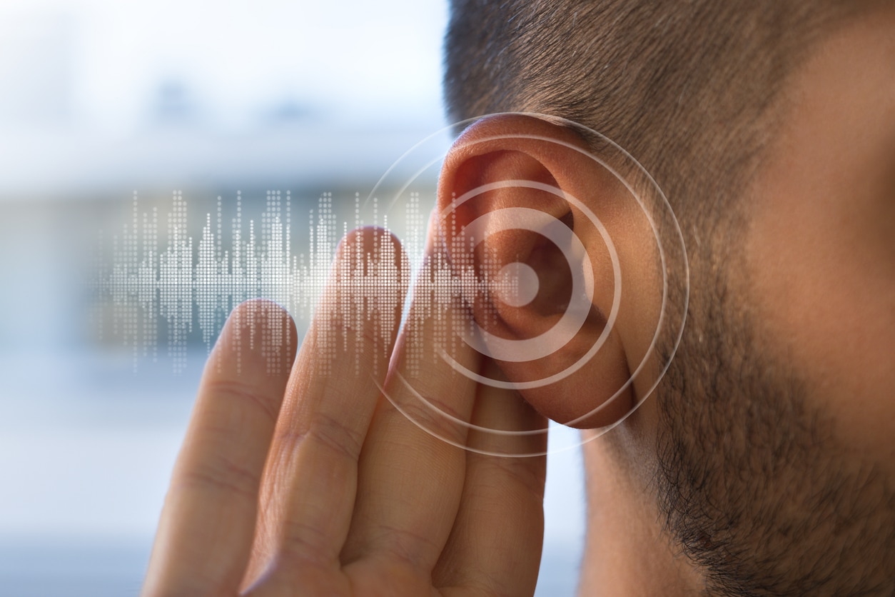 Close up of man holding hand behind ear