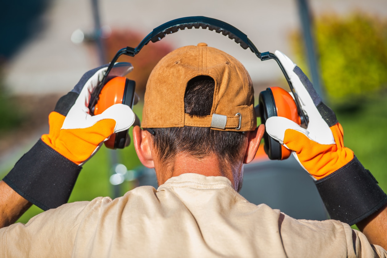 Man putting on earmuffs.