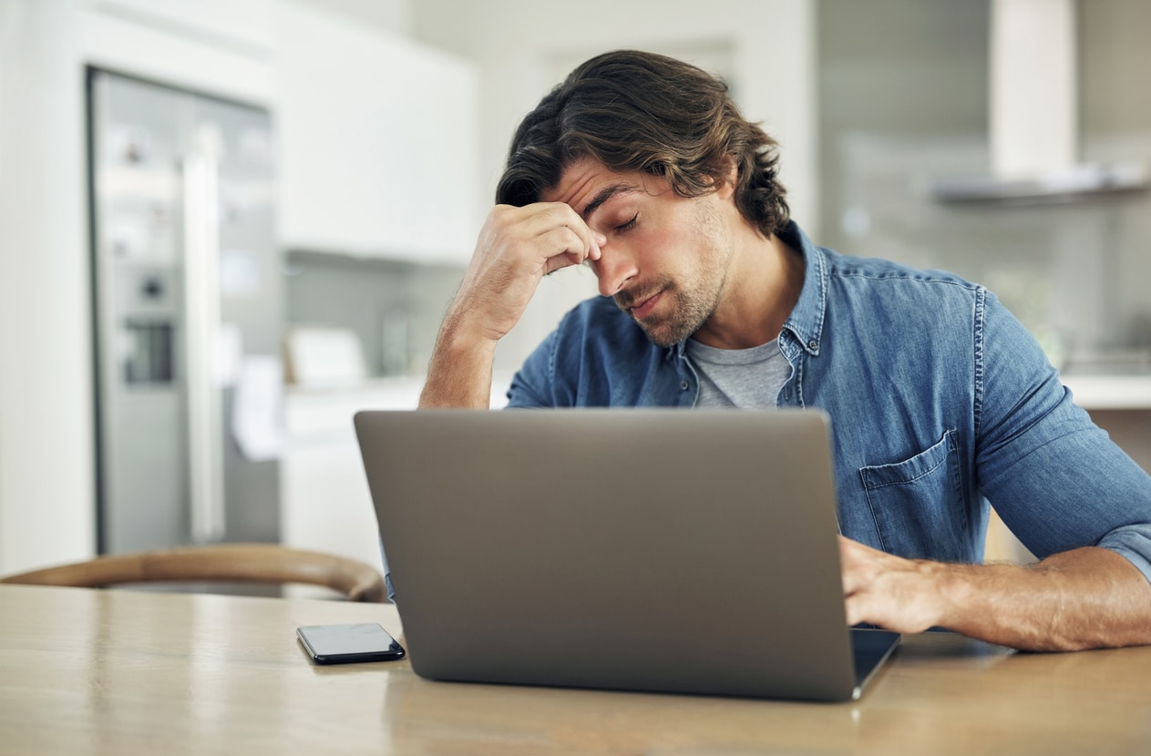 Stressed man holding his nose bridge.