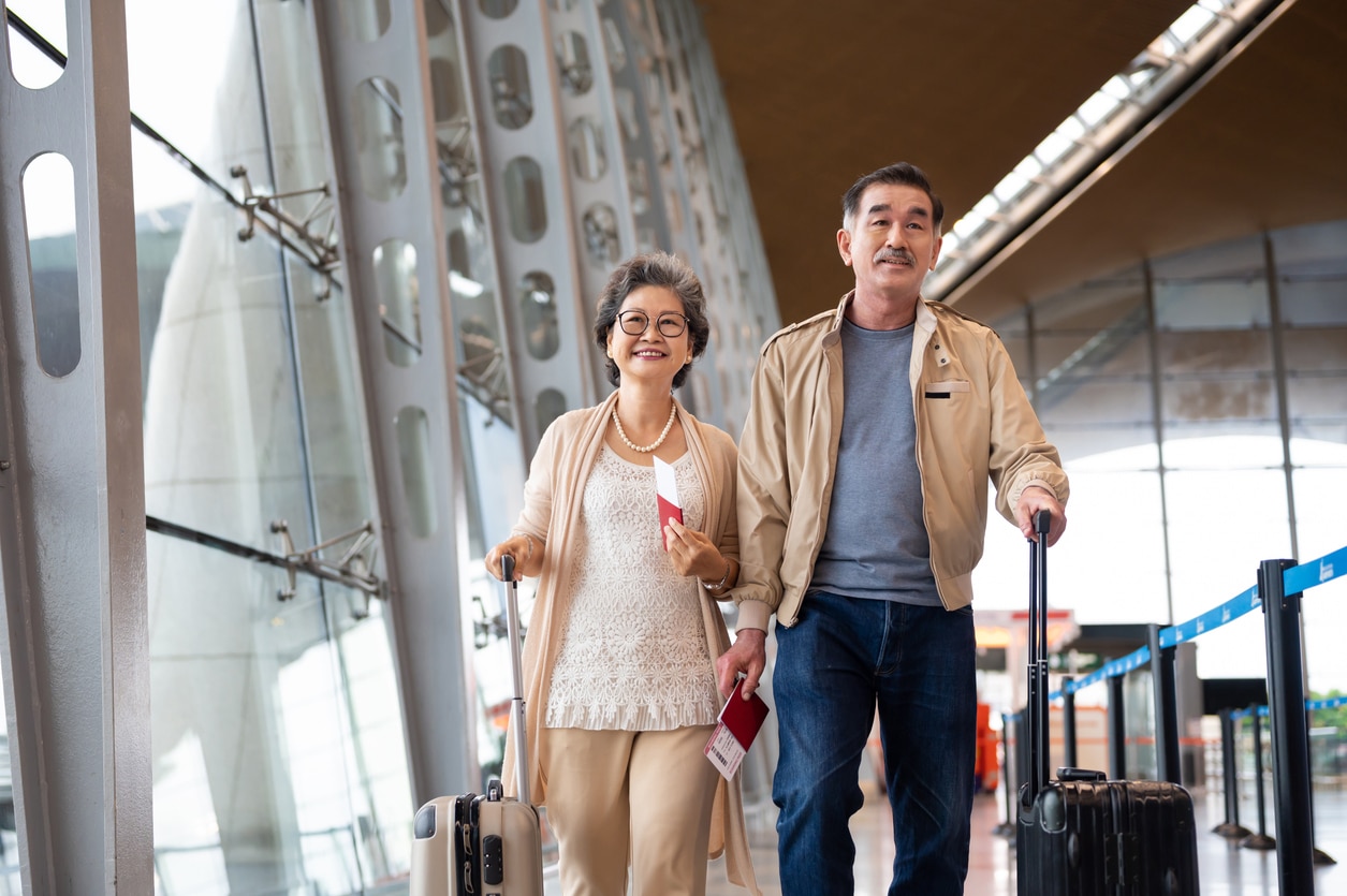 Couple walking through the airport with their suitcases.